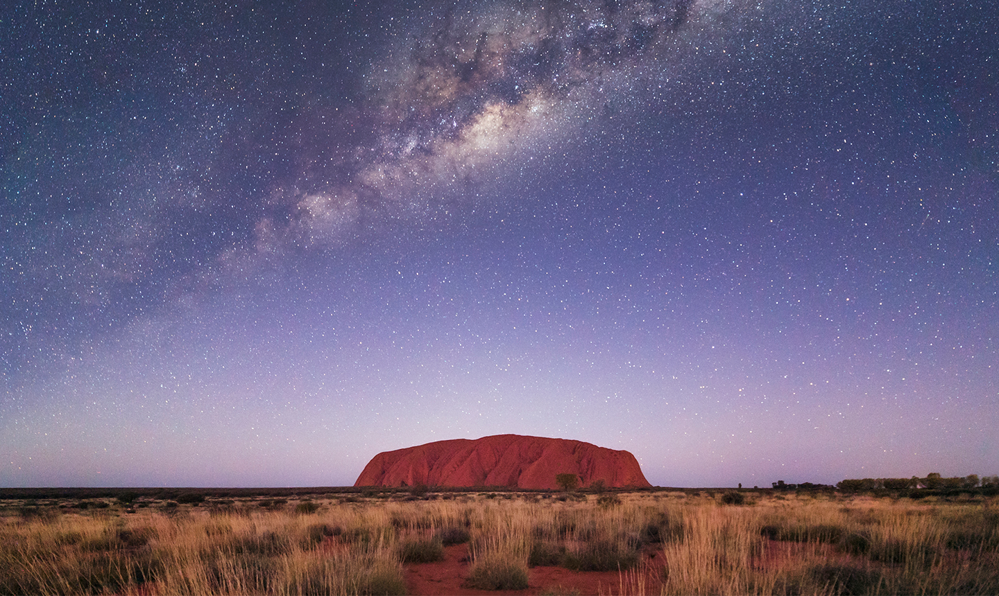 Uluru rock in Australia under milky way